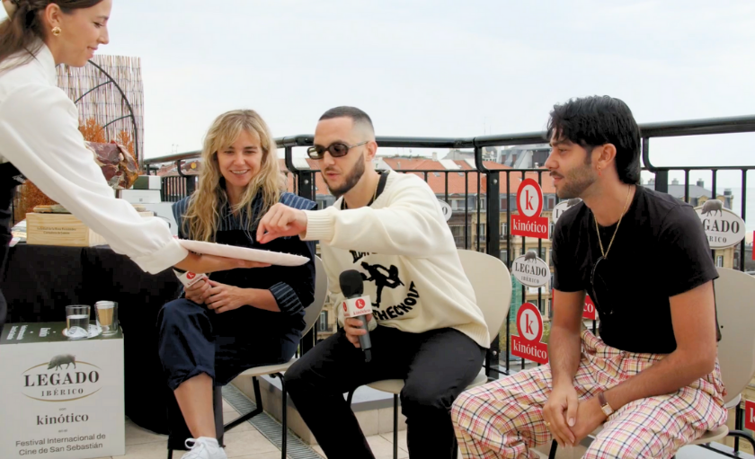 C Tangana cogiendo jamón Legado Ibérico en el set de entrevistas Kinótico en el festival de Cine de San Sebastián